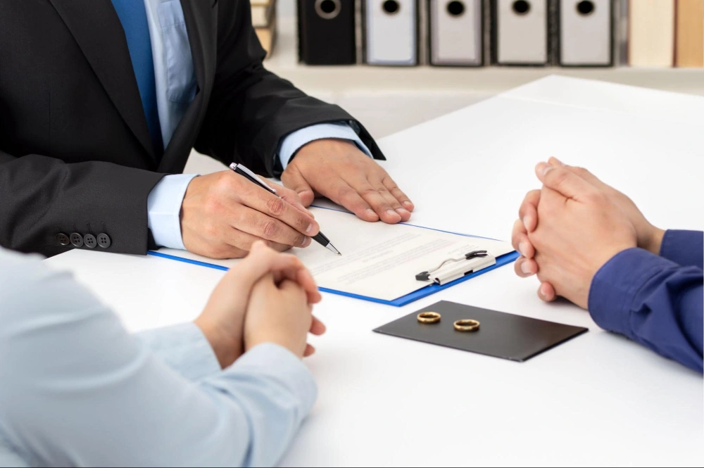 Divorce attorney discussing legal documents and financial planning options with a client