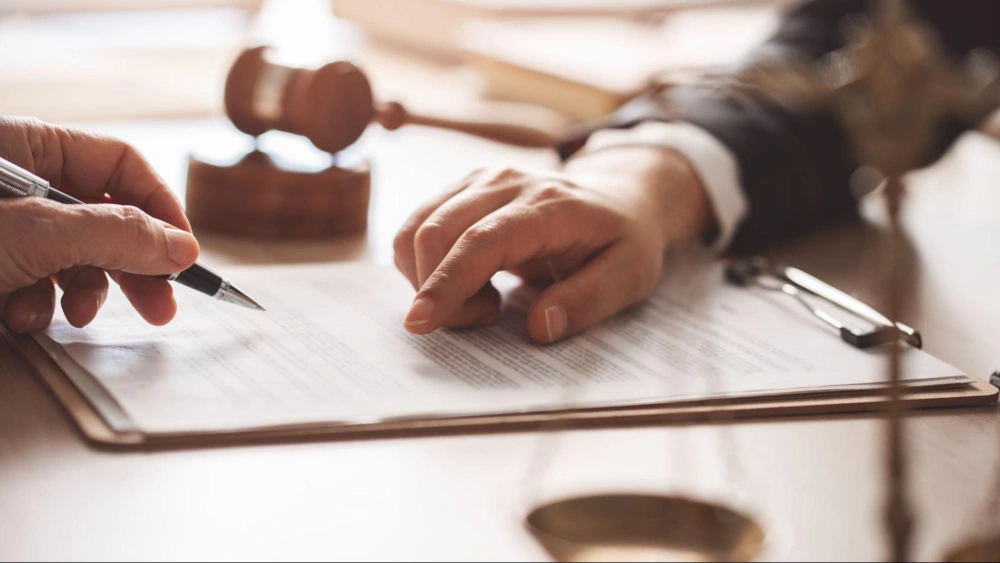 Estate planning attorney reviewing and signing legal documents with clients