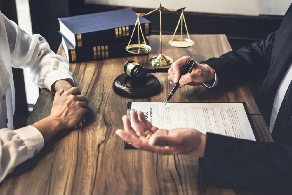 Spouses reviewing a divorce agreement with legal guidance during asset division